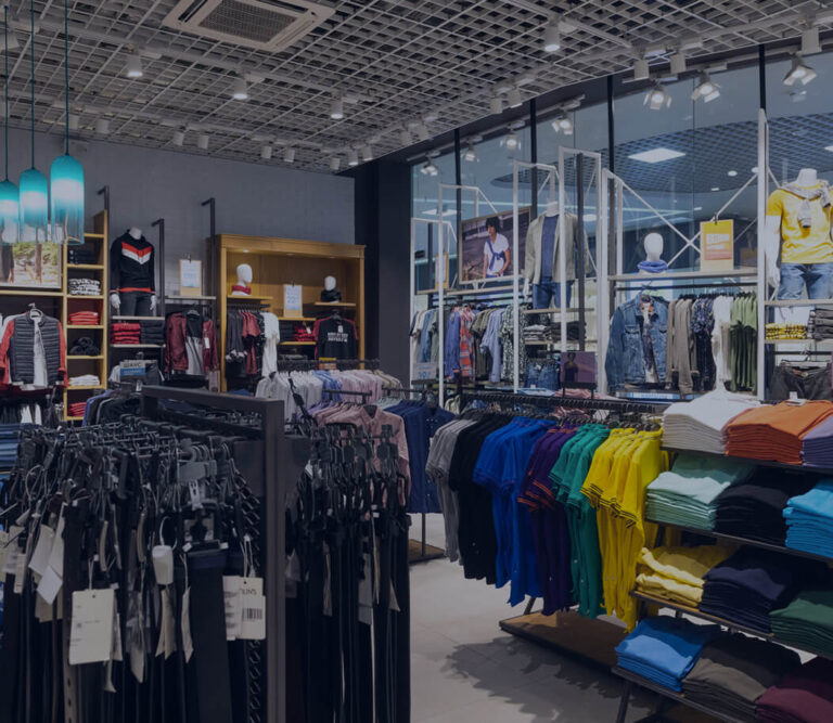 A clothing store interior showcasing various clothes and accessories displayed on racks and shelves.