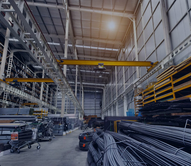 Industrial warehouse interior filled with steel pipes and various construction materials stacked on shelves.