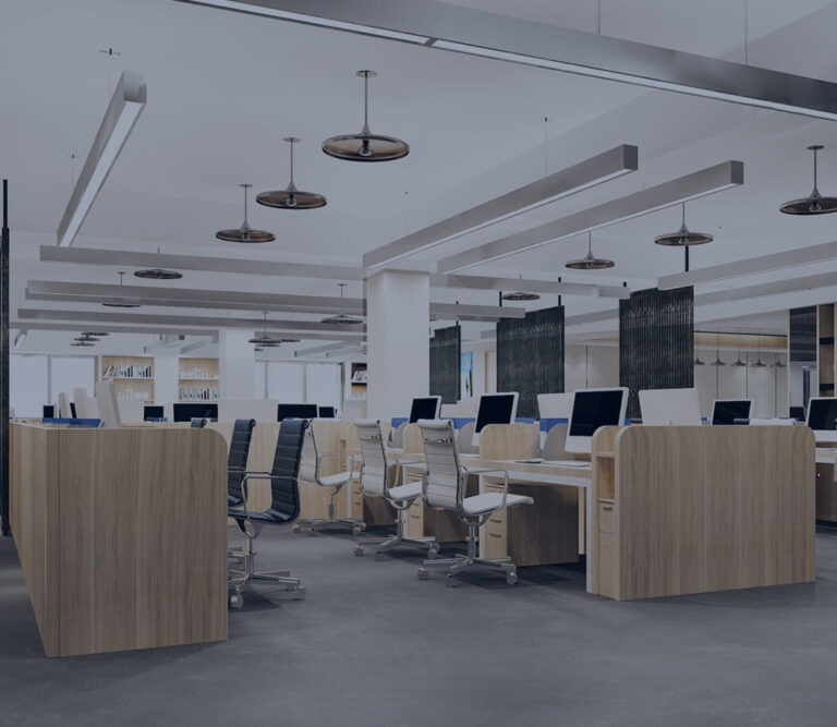 Modern office space featuring wooden desks, ergonomic chairs, and large windows, illuminated by stylish pendant lights.