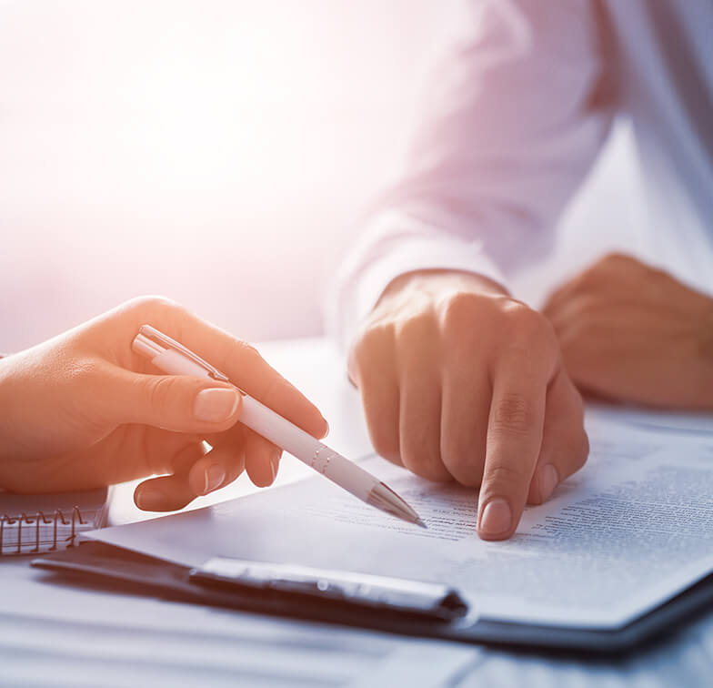 Two hands interact over a document on a table.