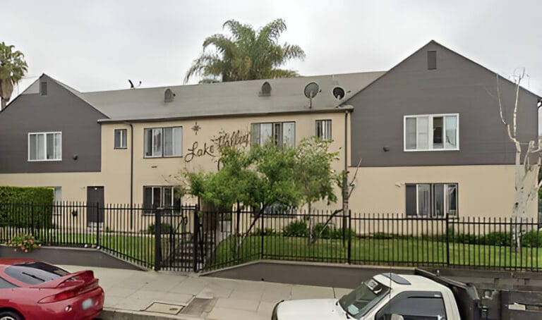 A gray apartment building with gated entrance.