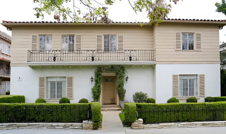 A house featuring a white front door and a balcony, showcasing a welcoming and charming exterior.