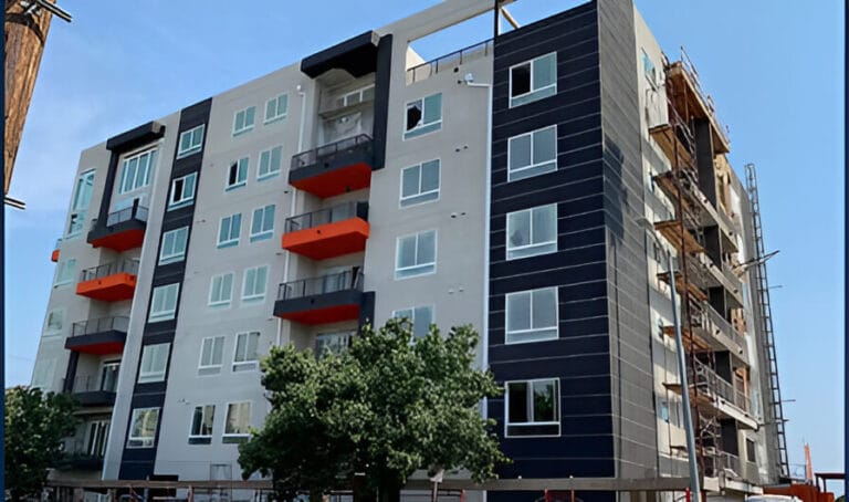 A large apartment building featuring orange and black balconies, showcasing a modern architectural design.