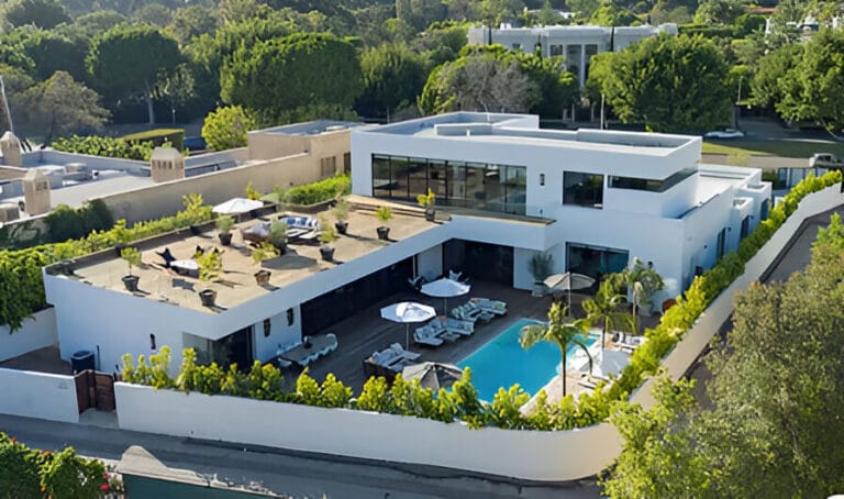 Aerial view of a contemporary home featuring a swimming pool surrounded by landscaped gardens.