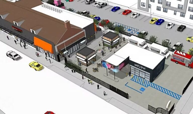 Aerial view of a lively outdoor plaza with food trucks, seating areas, and a surrounding building, filled with colorful cars and visitors.
